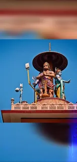 Colorful Indian rooftop sculpture against a clear blue sky.