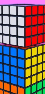 Stacked Rubik's Cubes on pink background.