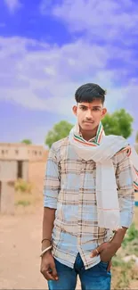 Young man in rural setting with blue sky background, wearing traditional attire.