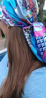 Vibrant scarf with blue patterns over hair.