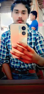 Selfie in checkered shirt with a mobile phone, vibrant and stylish.