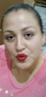 Selfie of a person with red lipstick wearing a pink top.