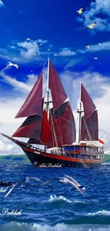 Majestic red sailboat on deep blue ocean with vibrant sky and soaring birds.