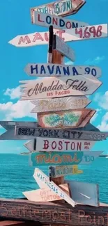 Colorful signpost by the sea under blue sky.