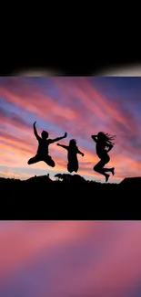 Silhouetted figures jumping against a vibrant sunset sky with colorful clouds.