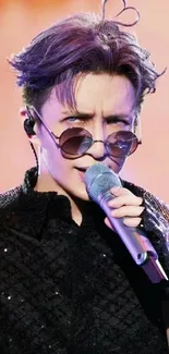 Singing artist with vibrant lighting and stylish sunglasses.