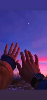 Hands reaching towards a vibrant purple and pink sunset sky with a visible star.