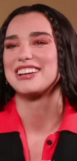 Smiling woman with vibrant red attire and braided hair.