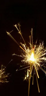 Two vibrant sparklers glowing in the dark with a black background.