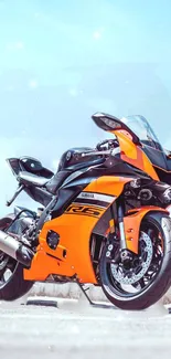 Orange and black sports motorcycle standing with a clear sky background.