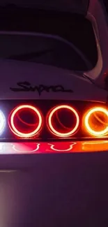 Close-up of car tail lights, vibrant red and orange glow.