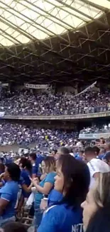 Vibrant stadium crowd in blue jerseys at a bustling arena.