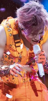 Performer in vibrant orange on stage with colorful lights.