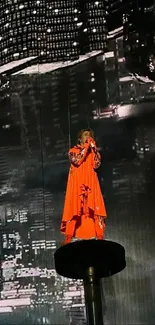 Performer in orange outfit against cityscape backdrop.