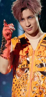 Performer in orange vest with decorative studs on stage.