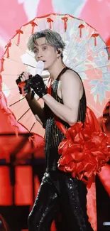 Dynamic performer with red parasol on stage wallpaper.