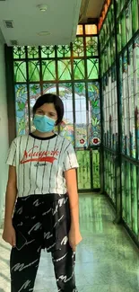 A person in a vibrant corridor with stained glass windows.