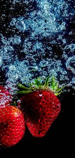 Strawberries splashing in water with vibrant red and blue hues.