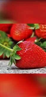 Close-up of a vibrant red strawberry with green leaves.