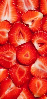 Close up of sliced strawberries creating a vibrant red wallpaper.