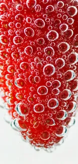 Close-up of a red strawberry with bubbles on a vibrant background.