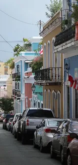 Vibrant street with colorful buildings and parked cars.