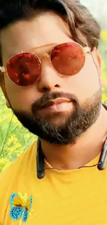 Stylish man with beard in red sunglasses and yellow shirt outdoors.