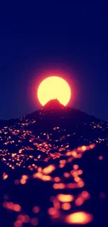 Vibrant sunset over mountain with glowing sun and dark landscape.