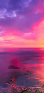 Vibrant sunset over a serene beach with pink and purple hues.