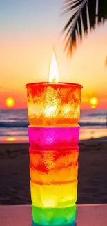 Colorful candle with vibrant sunset on beach.