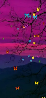 Vibrant pink sunset over dark mountains with bare branches.