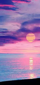 Vibrant sunset over ocean with pink and purple skies.