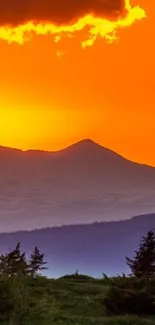 Vibrant orange sunset over mountain silhouette with clear sky.