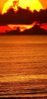 Vivid sunset over ocean with warm orange glow and calm waves.