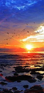 Vibrant sunset over ocean with birds in flight.