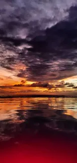 Vibrant sunset over ocean with purple and orange hues reflected on water.