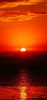 Stunning sunset over the ocean with vibrant orange-red hues.