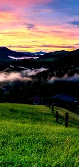 Vibrant sunset with clouds over green hills and mountains.