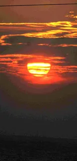 Vibrant sunset over ocean with red-orange hues.