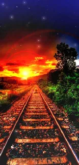 Railway tracks lead into a vibrant orange sunset, surrounded by lush greenery.