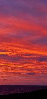 Sunset with vivid orange and purple hues, featuring a silhouetted figure by the sea.