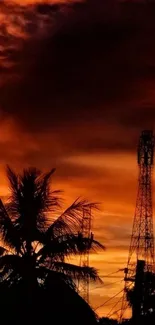 Silhouette of palm trees against a vibrant orange sunset sky.