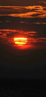 Vibrant sunset with deep red and orange hues over the ocean horizon.