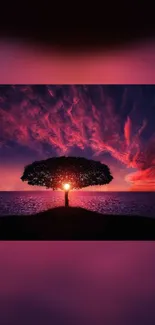 Vibrant sunset over ocean with silhouetted tree.