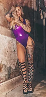 Tattooed woman in purple outfit striking a pose against a textured wall.