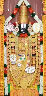 Hindu temple deity adorned with gold and colorful garlands.