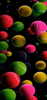 Colorful tennis balls on black background wallpaper.