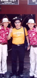 Smiling visitors at a vibrant theme park entrance.