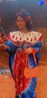 Woman in vibrant red tie-dye dress taking a selfie.