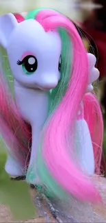 Vibrant toy pony with pink and green hair on mobile wallpaper.